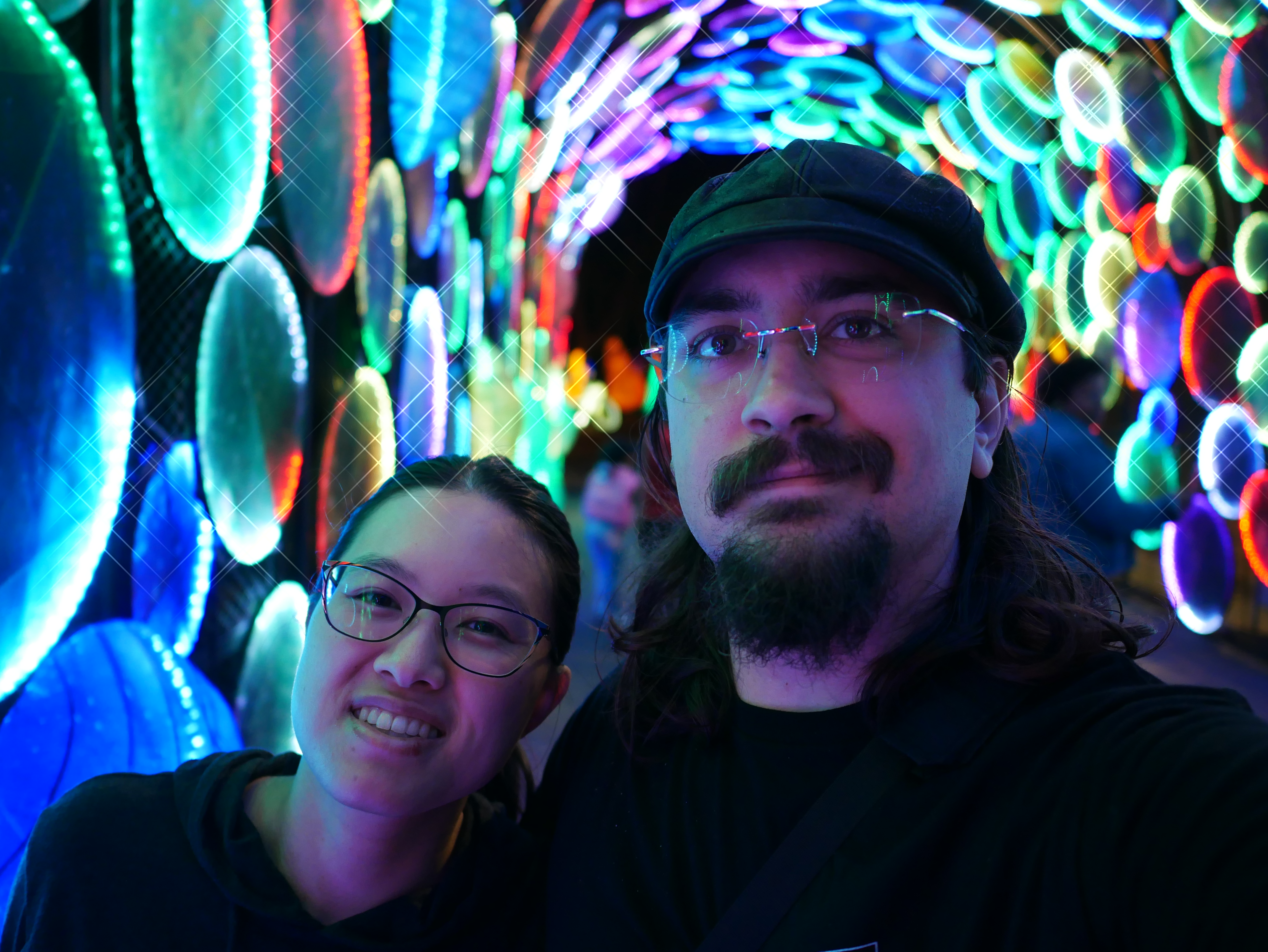 Megan and Andrew in a rainbow tunnel at Boston Lights in Franklin Park Zoo